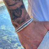 gray rope bracelet on hand with tattoo